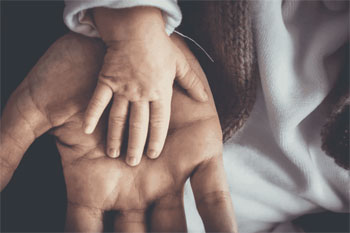 La tenerezza delle mani del papà e del figlio